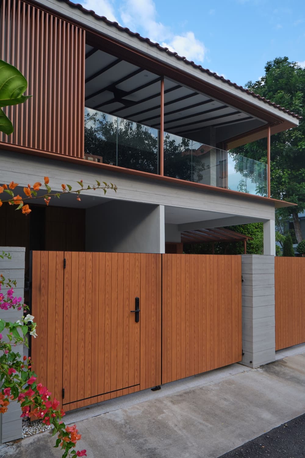 The timber gate and screened upper storey seen from the street at A Sensory House, a luxury landed house in Singapore by K2SD Group