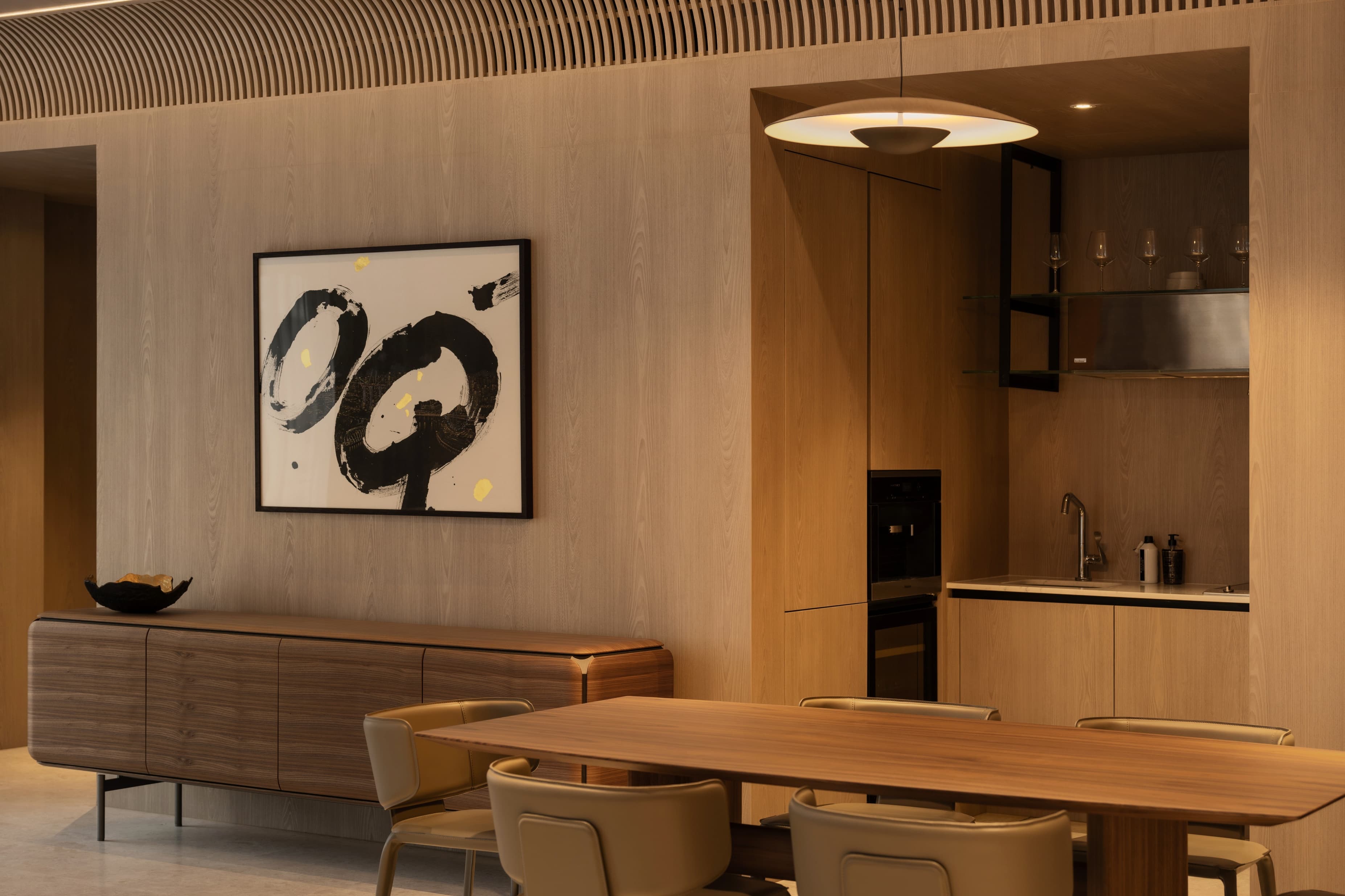 A wood-panelled kitchen and dining room with a black calligraphy painting